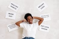 Smiling woman embracing positive lifestyle with healthy living messages around her.